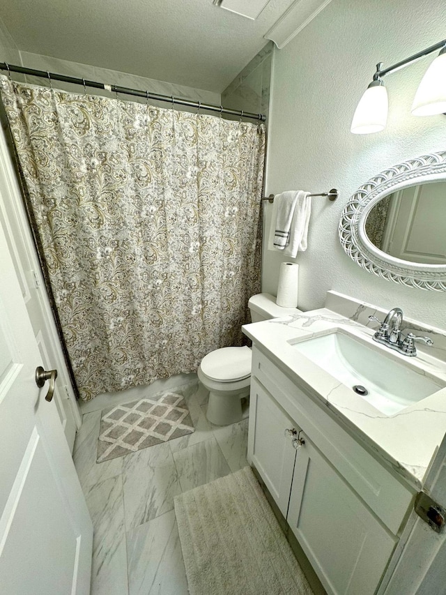 bathroom with vanity, a textured ceiling, and toilet