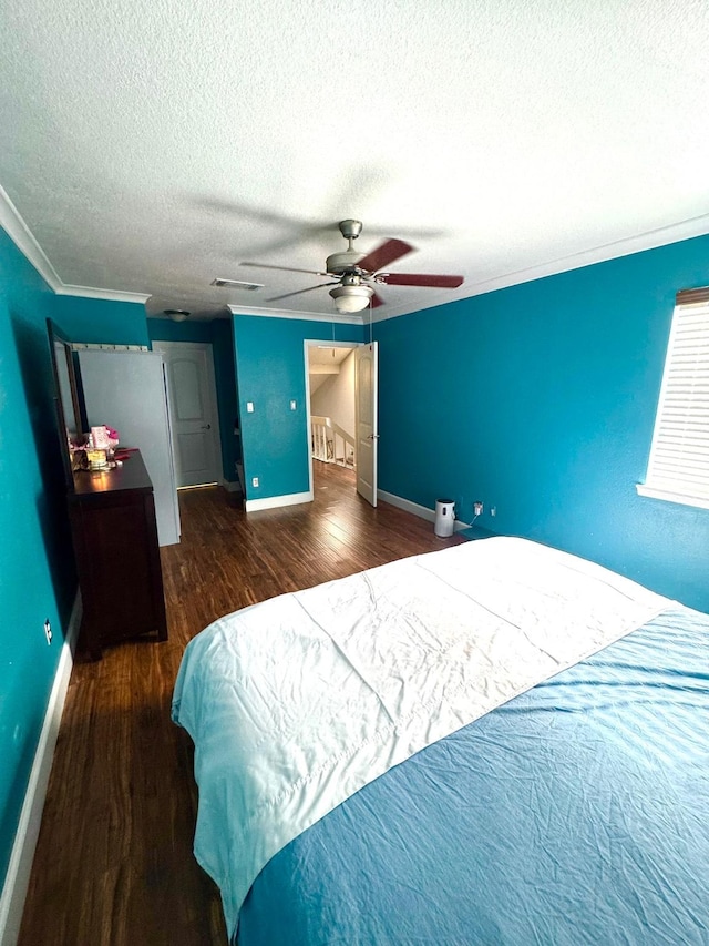 bedroom featuring a textured ceiling, ceiling fan, crown molding, and dark hardwood / wood-style floors