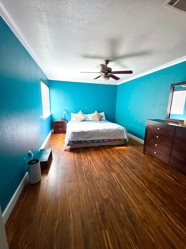 unfurnished bedroom with hardwood / wood-style flooring, ceiling fan, crown molding, and a textured ceiling