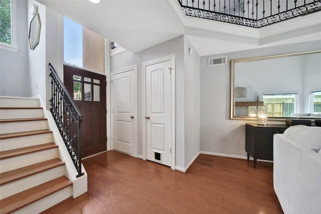 foyer with hardwood / wood-style floors and a towering ceiling