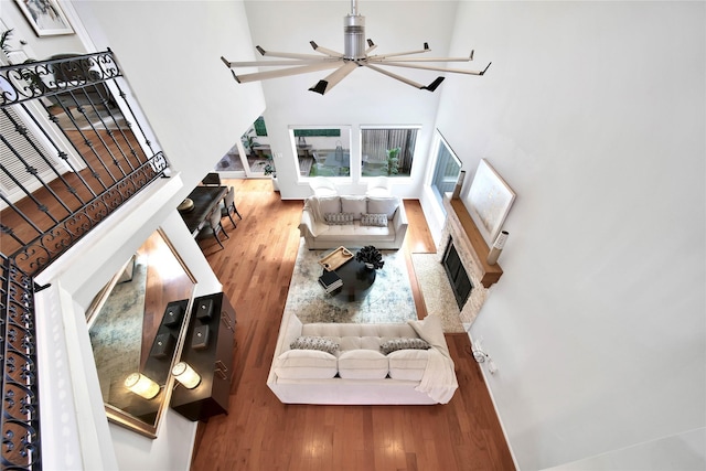 living room featuring ceiling fan, wood-type flooring, and a high ceiling