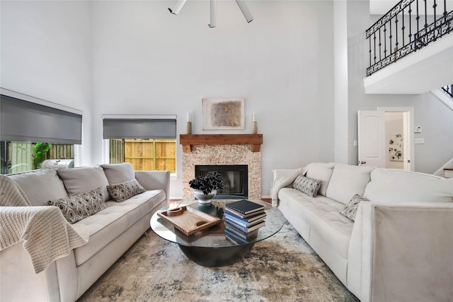 living room with a towering ceiling and a fireplace