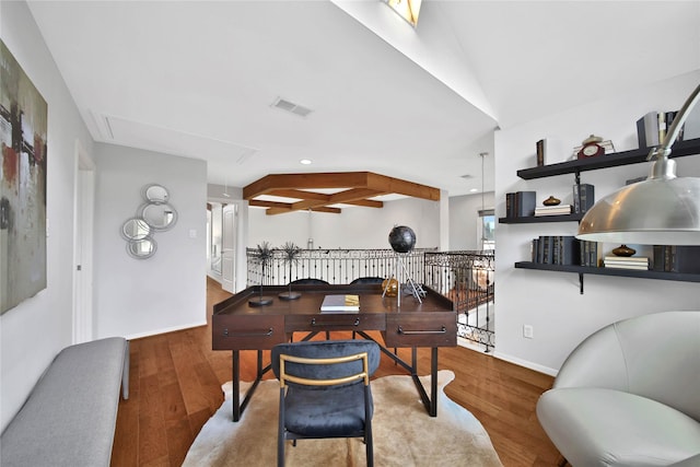 dining space featuring wood-type flooring and lofted ceiling with beams