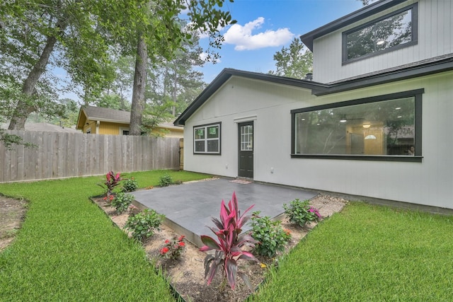 back of property featuring a patio area and a yard