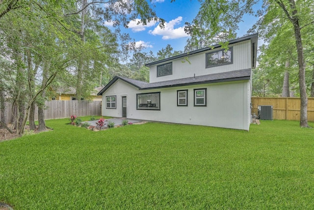 rear view of property featuring central AC unit, a patio, and a lawn