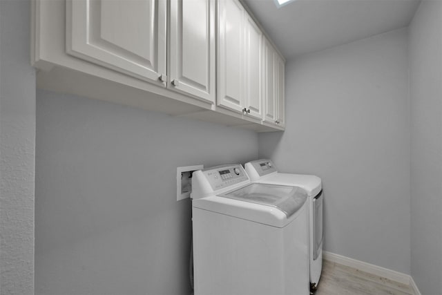 laundry room featuring cabinets, independent washer and dryer, and light wood-type flooring