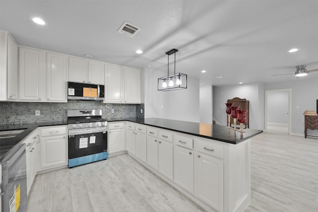 kitchen with white cabinets, decorative light fixtures, and stainless steel appliances