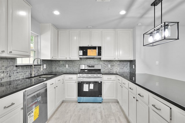 kitchen featuring white cabinetry, sink, pendant lighting, and appliances with stainless steel finishes