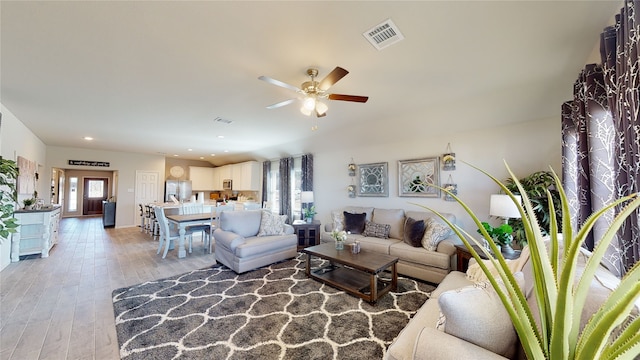 living room featuring ceiling fan and light hardwood / wood-style floors