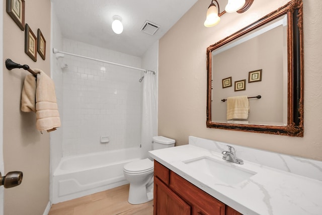 full bathroom with toilet, tile patterned floors, tiled shower / bath, and vanity