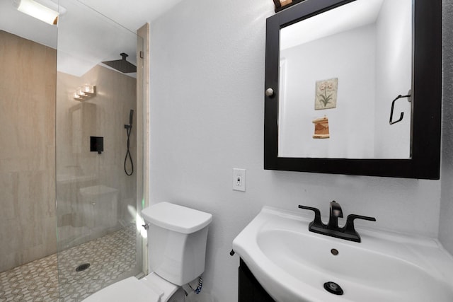 bathroom with sink, toilet, and a tile shower