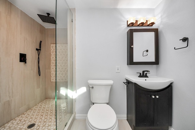 bathroom featuring toilet, vanity, and a tile shower