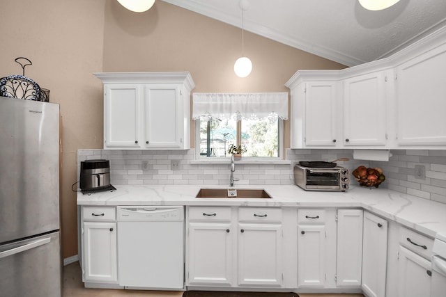 kitchen with light stone countertops, dishwasher, white cabinetry, sink, and stainless steel fridge