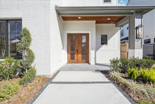 property entrance featuring french doors and brick siding