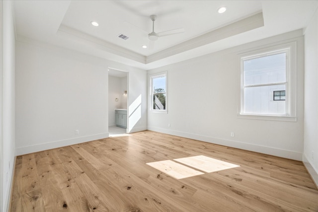 unfurnished bedroom with recessed lighting, visible vents, baseboards, light wood-type flooring, and a tray ceiling