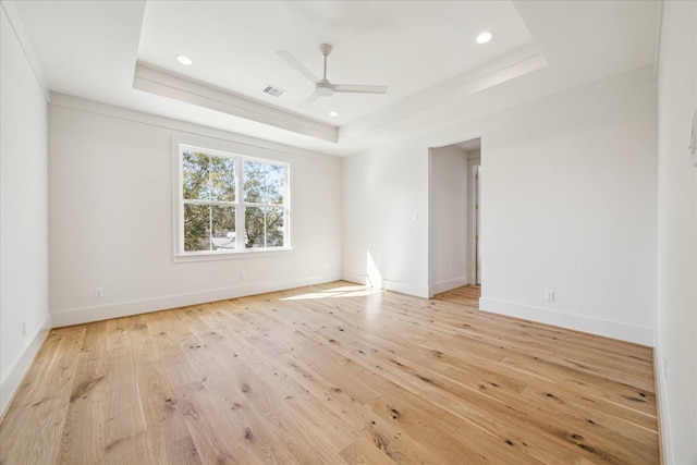 unfurnished room featuring recessed lighting, a ceiling fan, baseboards, light wood-style floors, and a tray ceiling