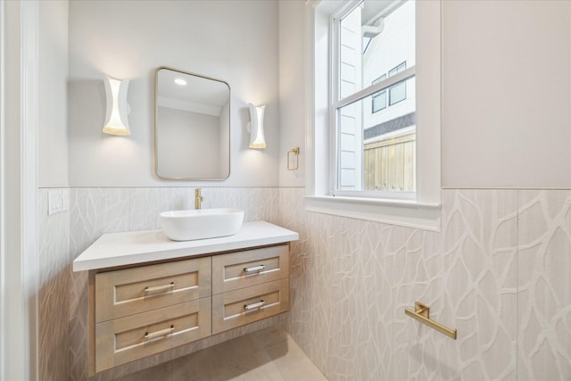 bathroom featuring vanity, tile walls, and wainscoting