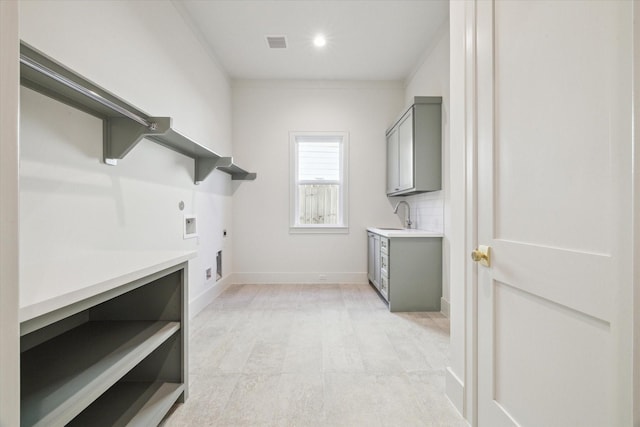 laundry area featuring cabinet space, baseboards, visible vents, hookup for an electric dryer, and a sink