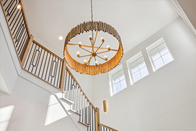 stairway with a chandelier and a high ceiling