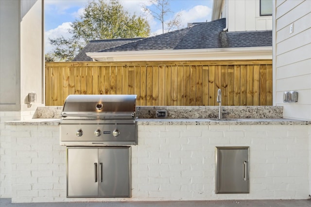 view of patio / terrace featuring a sink, fence, and area for grilling