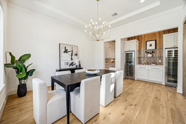 dining room featuring beverage cooler, visible vents, and a raised ceiling