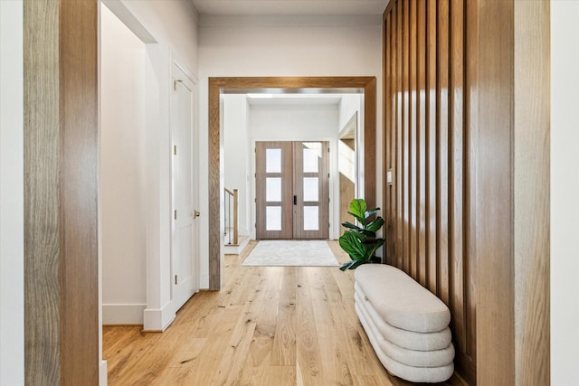 foyer featuring light wood finished floors and french doors