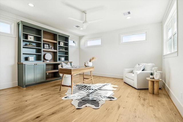 office area featuring light wood-type flooring, baseboards, visible vents, and ceiling fan