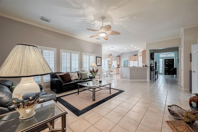 tiled living room with ceiling fan, lofted ceiling, and ornamental molding