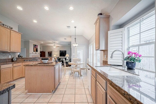 kitchen with light brown cabinetry, sink, decorative light fixtures, and decorative backsplash