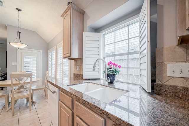 kitchen featuring light brown cabinetry, white dishwasher, hanging light fixtures, light tile patterned floors, and sink