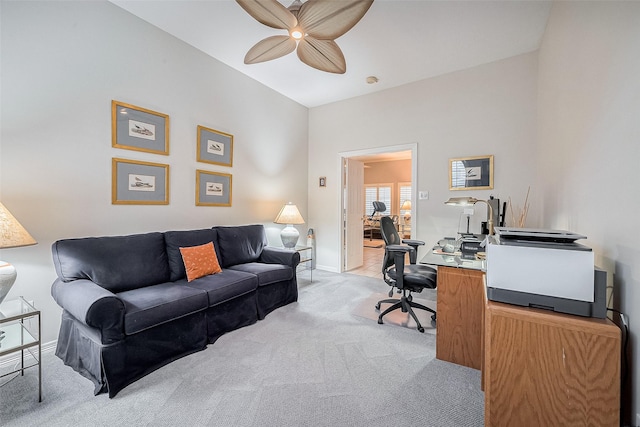 office space with vaulted ceiling, ceiling fan, and light colored carpet