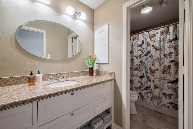 bathroom with vanity, toilet, and tile patterned floors