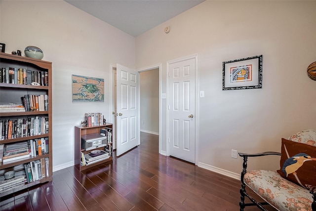 sitting room with dark wood-type flooring