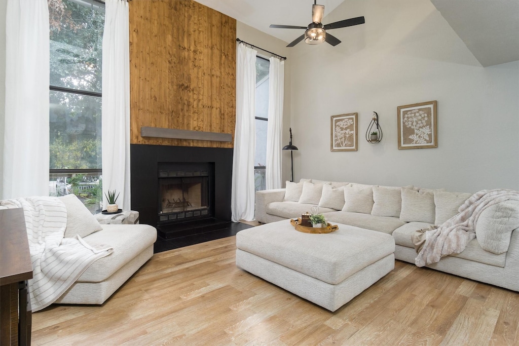 living room with hardwood / wood-style floors, vaulted ceiling, and ceiling fan