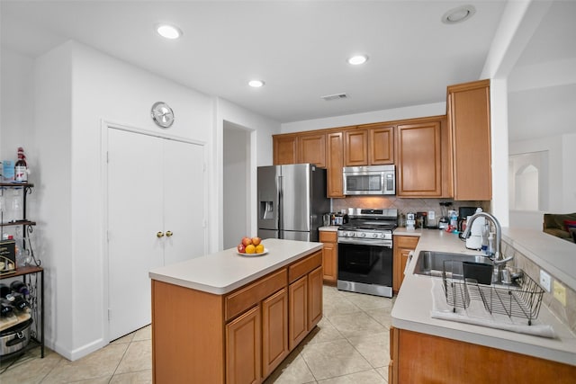 kitchen with sink, a center island, tasteful backsplash, light tile patterned floors, and appliances with stainless steel finishes