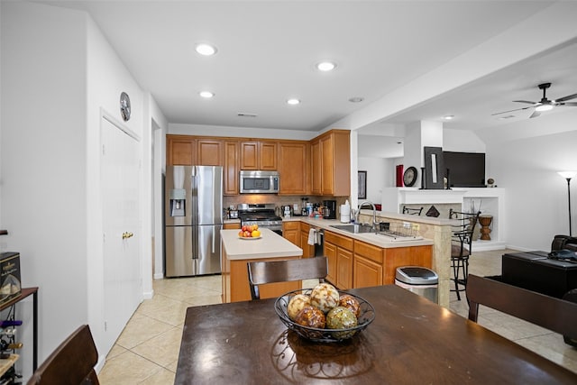 kitchen with ceiling fan, sink, stainless steel appliances, tasteful backsplash, and kitchen peninsula