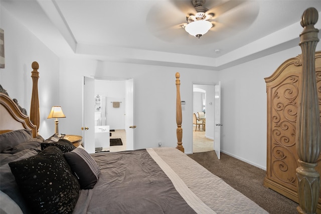 carpeted bedroom with ceiling fan and a tray ceiling