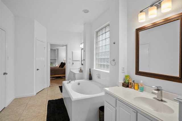 bathroom with tile patterned floors, vanity, a washtub, and a wealth of natural light