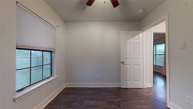 unfurnished room featuring dark hardwood / wood-style floors, ceiling fan, and a healthy amount of sunlight