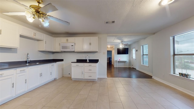 kitchen featuring white cabinetry, sink, ceiling fan, and a textured ceiling