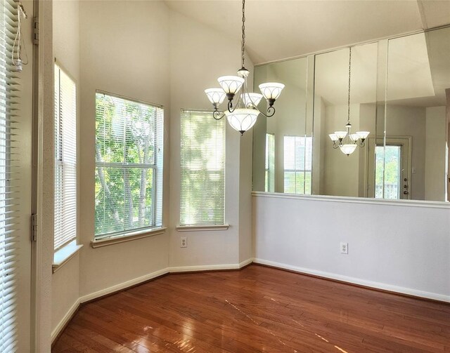 unfurnished dining area featuring hardwood / wood-style flooring and a notable chandelier