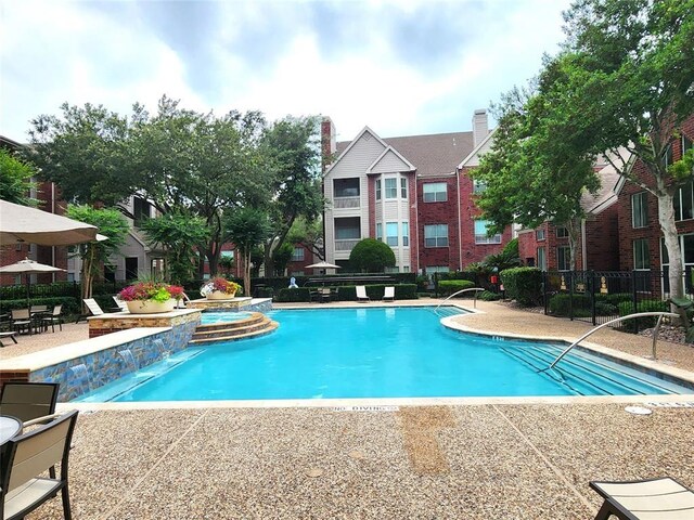 view of swimming pool featuring pool water feature and a patio