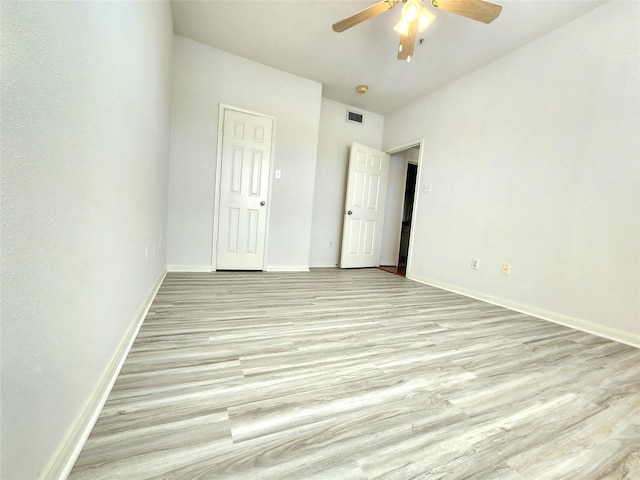 empty room with light hardwood / wood-style flooring and ceiling fan