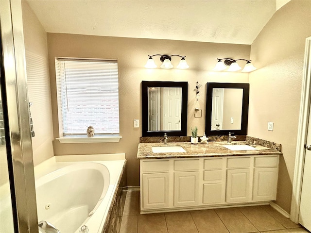 bathroom with tile patterned floors, vanity, and a relaxing tiled tub