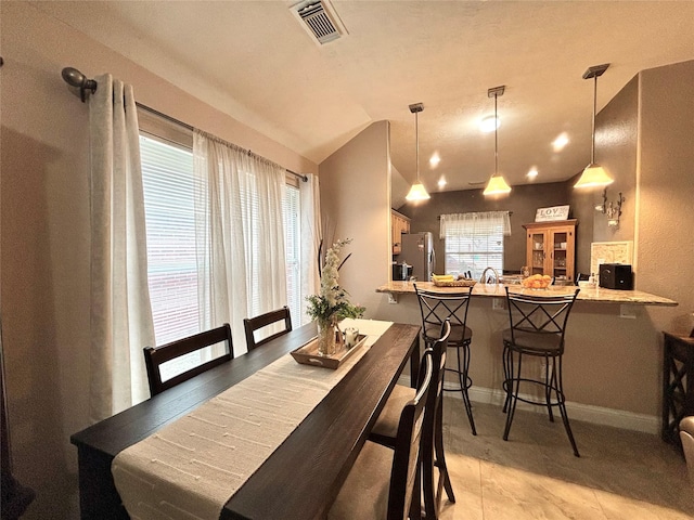 tiled dining space featuring lofted ceiling