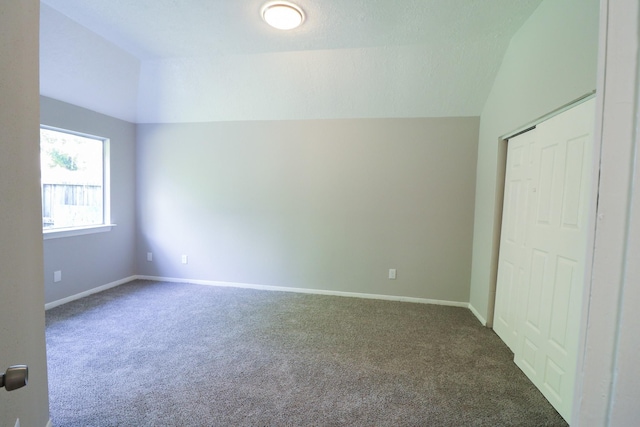 unfurnished bedroom featuring carpet floors and vaulted ceiling