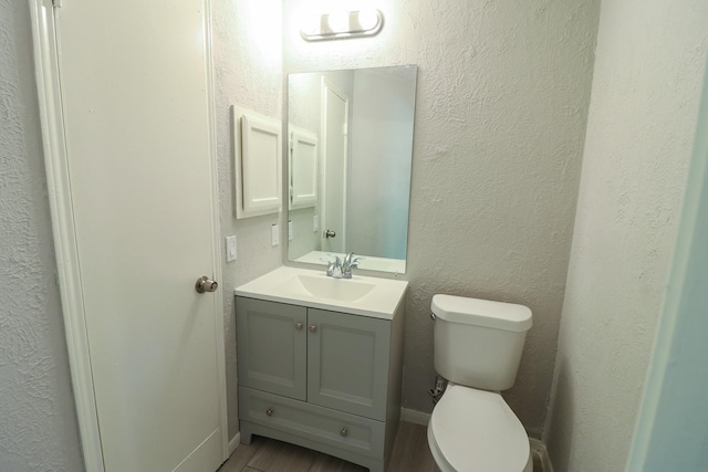 bathroom featuring vanity, wood-type flooring, and toilet