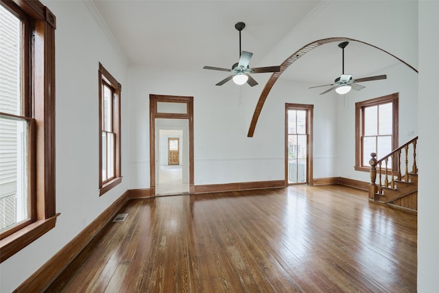 spare room featuring baseboards, visible vents, dark wood-style floors, ornamental molding, and stairs