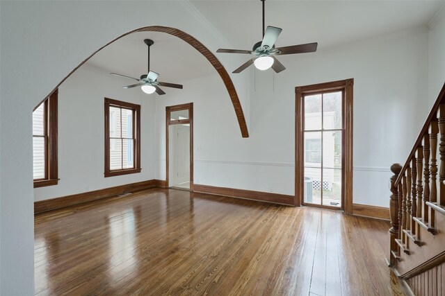 unfurnished living room featuring ceiling fan, hardwood / wood-style flooring, and ornamental molding