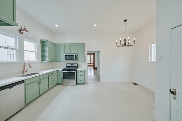 kitchen with decorative light fixtures, sink, green cabinets, an inviting chandelier, and stainless steel appliances